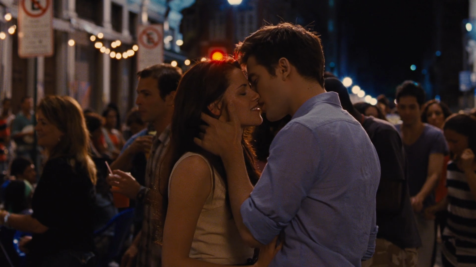 Bella and Edward kiss amid the nighttime crowd in Lapa